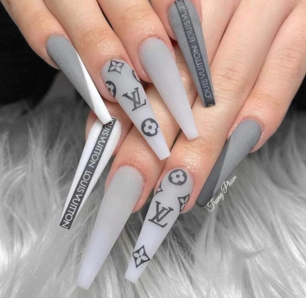 Nagelartist använder LV LOUIS VUITTON Blomma nagelklistermärken skapar gråa vita rosa lyxiga naglar på kunden. Nail stickers nageldekorationer Nail decoration Modemärken